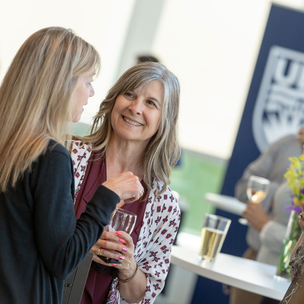 Two UBCO staff members chat at a UBC event